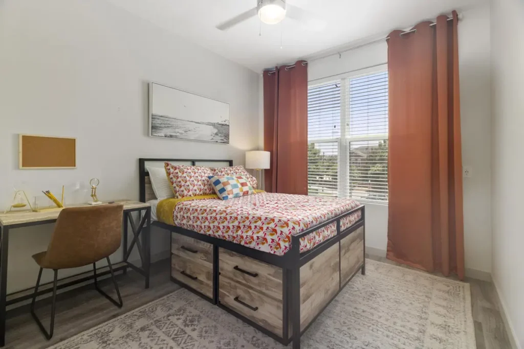 Student apartment bedroom with workspace at 320 West Mag in Auburn, Alabama.